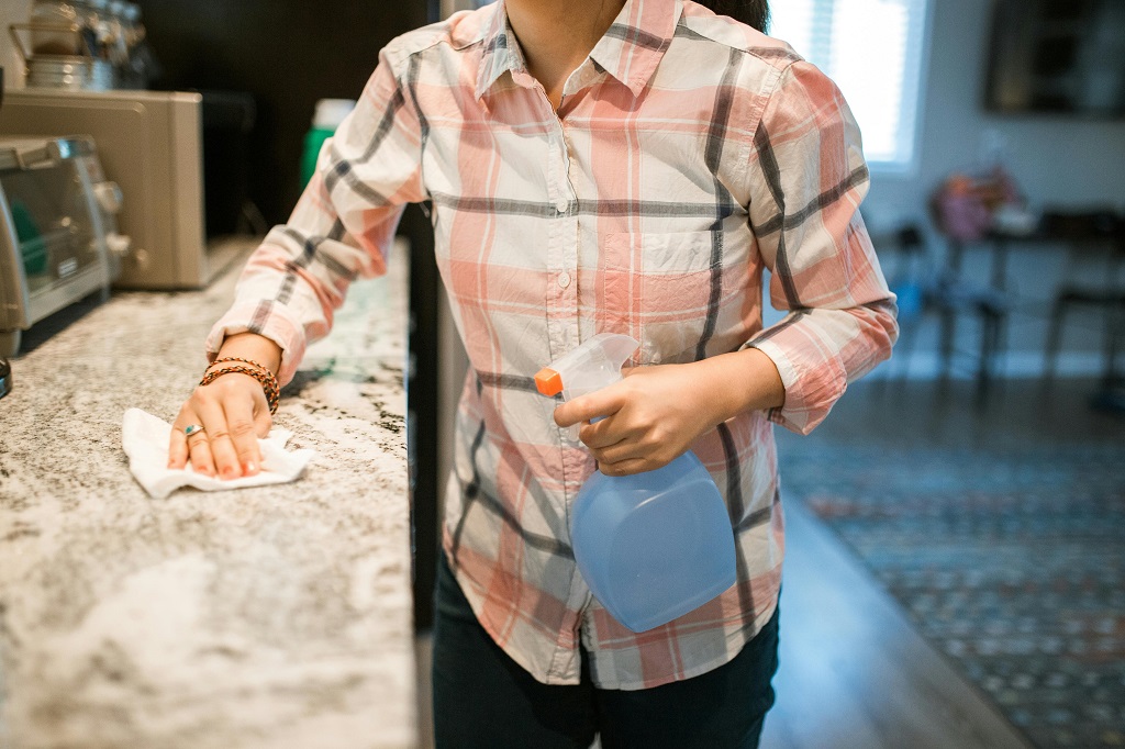 woman cleaning a quartz kitchen countertop